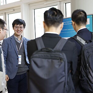 EPTS - Poster Session with the participants standing in front of a poster and reading